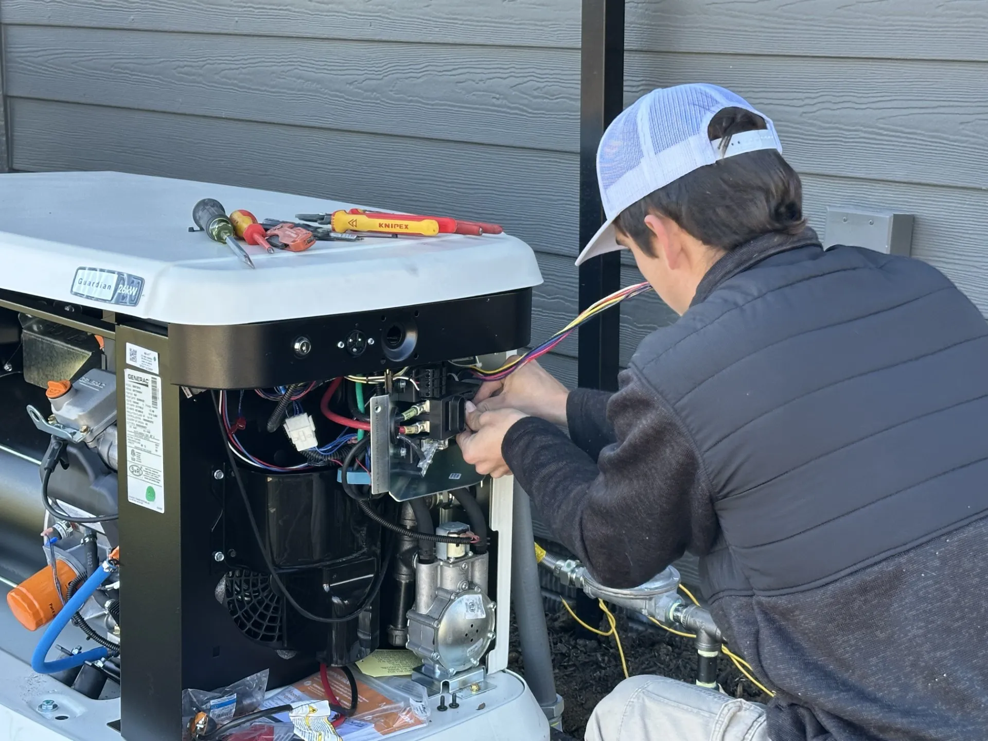 Bluffs Electric technician performing annual maintenance on a Generac generator
